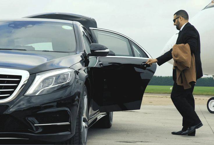 Chauffeur assisting a passenger with luggage at Adelaide Airport